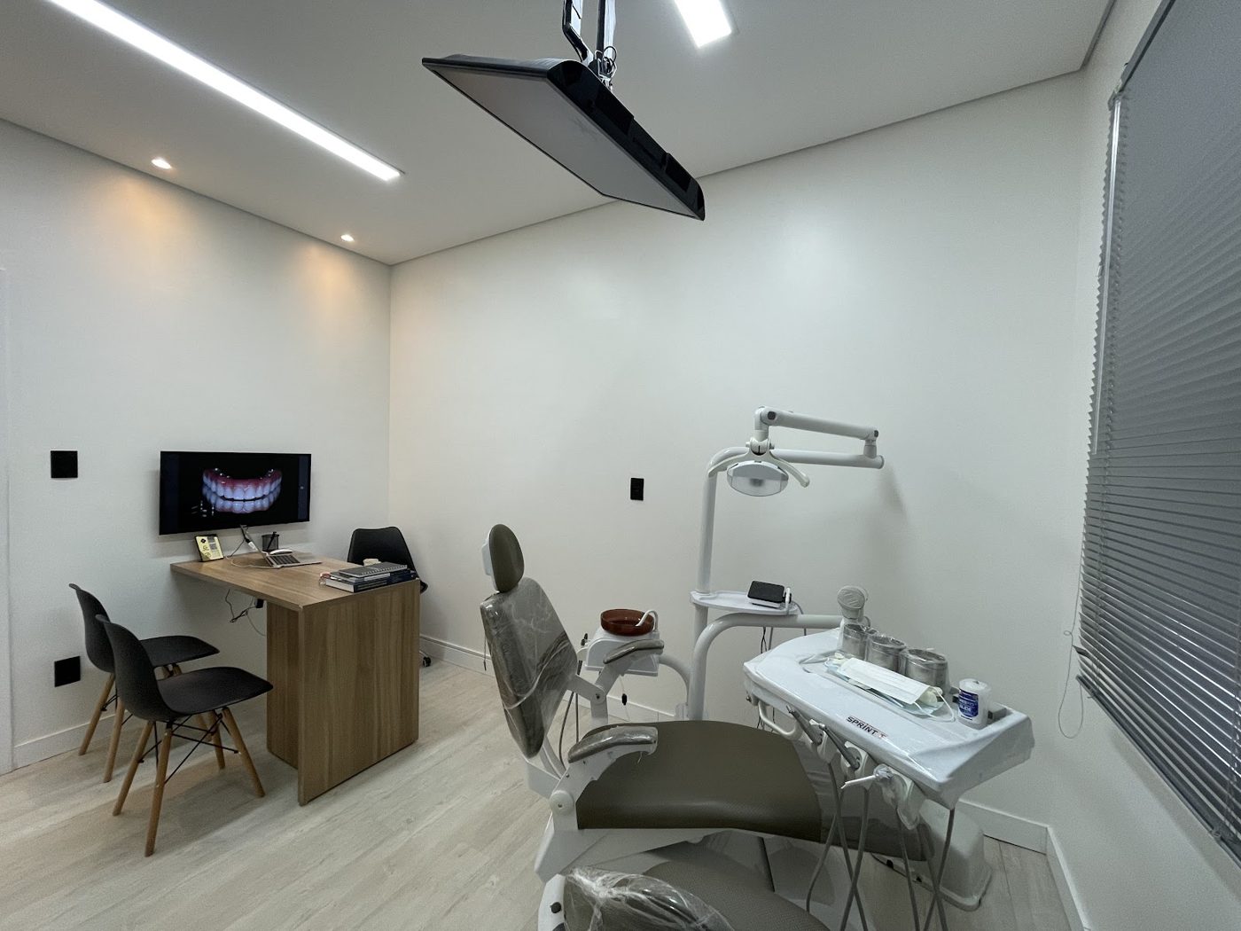 Consultório da Vallos Odontologia com cadeira odontológica e monitor